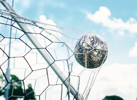 Photographie d'un balon de foot rentrant dans les filets