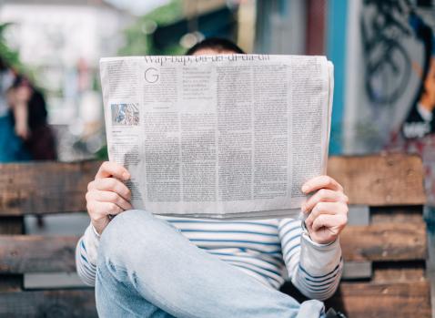 Photographie d'un homme lisant un journal