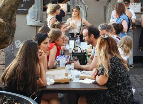 Photographie de personnes déjeunants sur une table en bois