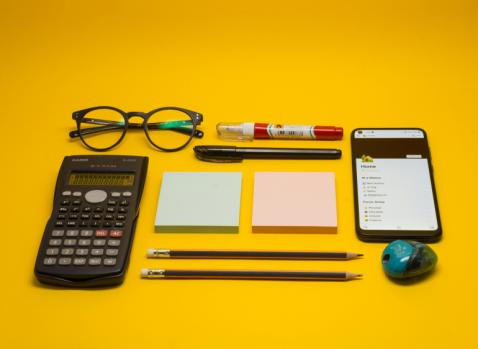 Photographie d'une calculatrice, de stylos et de post it