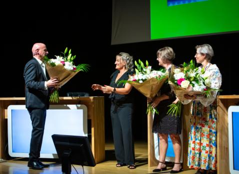 Photographie de PIerre Marx offrant des fleurs à ses collaboratrices