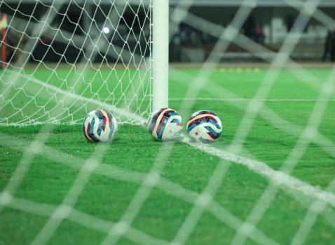 Photographie de ballons de foot sur un terrain