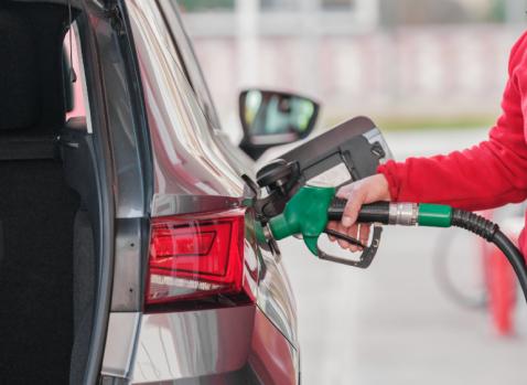 Photographie d'une personne mettant de l'essence dans une voiture